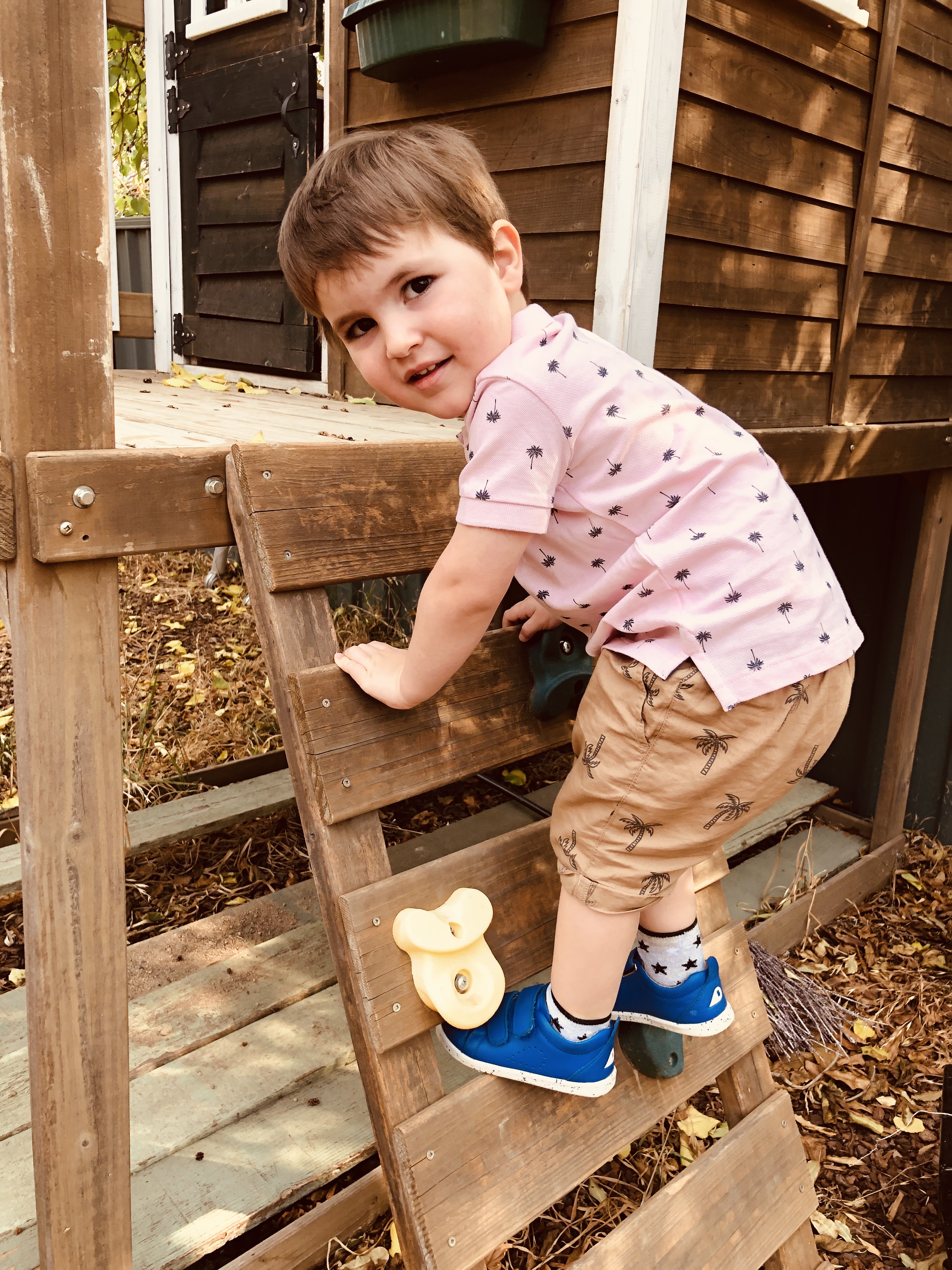 Little boy on climbing frame wearing Bobux shoes