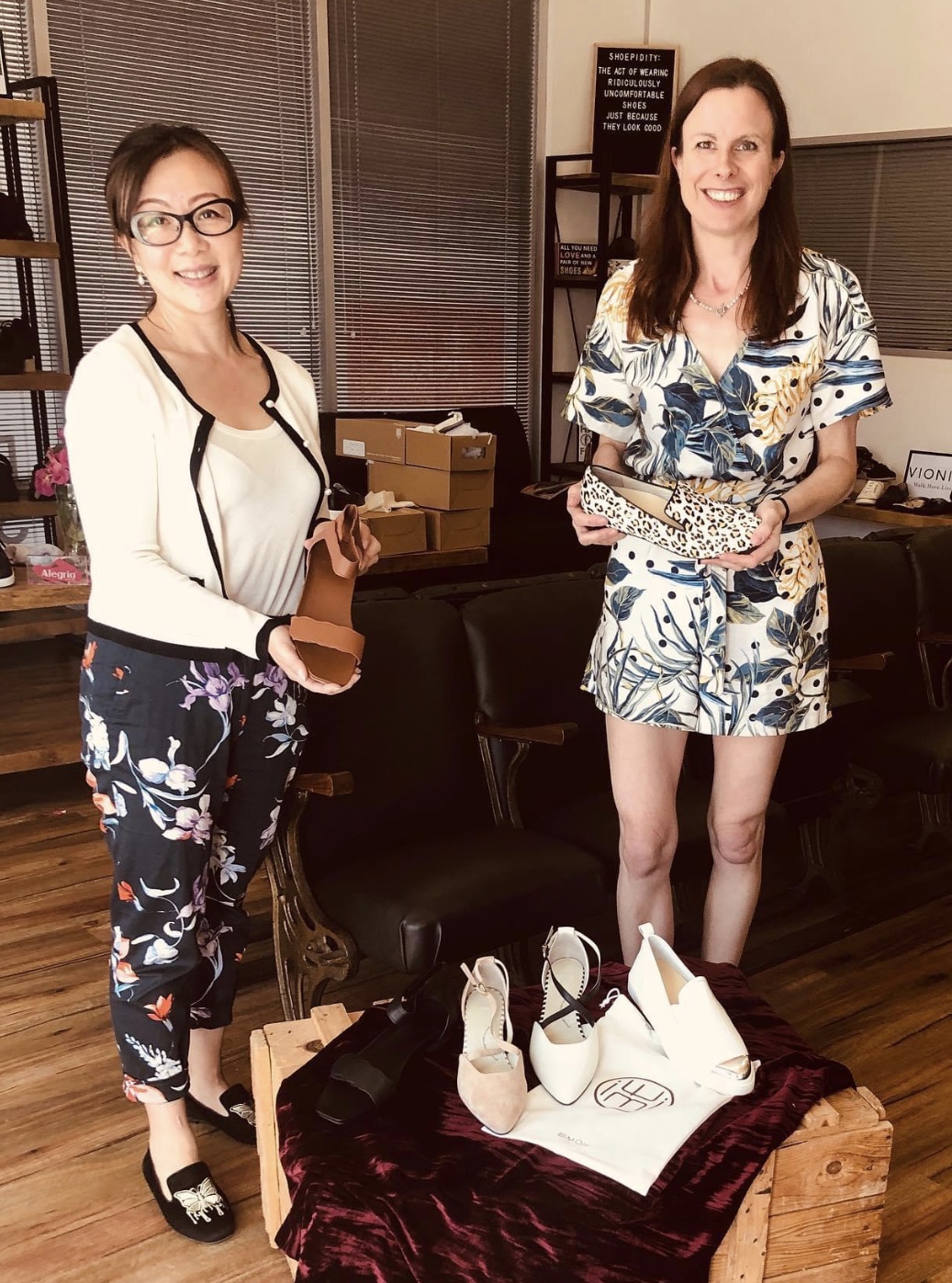 Image of two ladies happily holding shoes